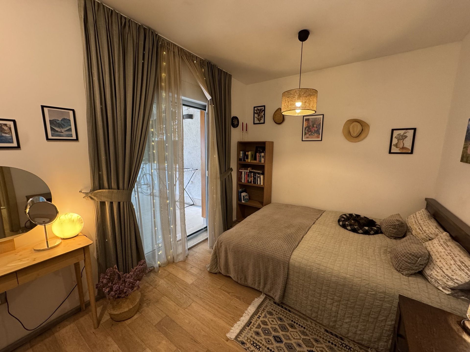 Cozy bedroom with a double bed, vanity table, and access to the balcony in an apartment, Dobrota, Montenegro.