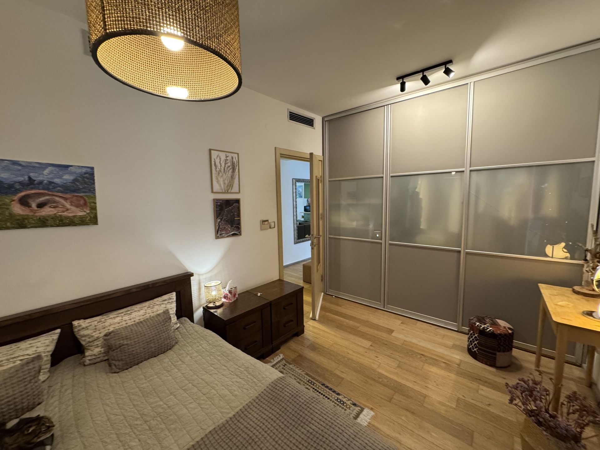 Cozy bedroom in an apartment in Dobrota, Montenegro: double bed, large built-in wardrobe, and stylish lighting.
