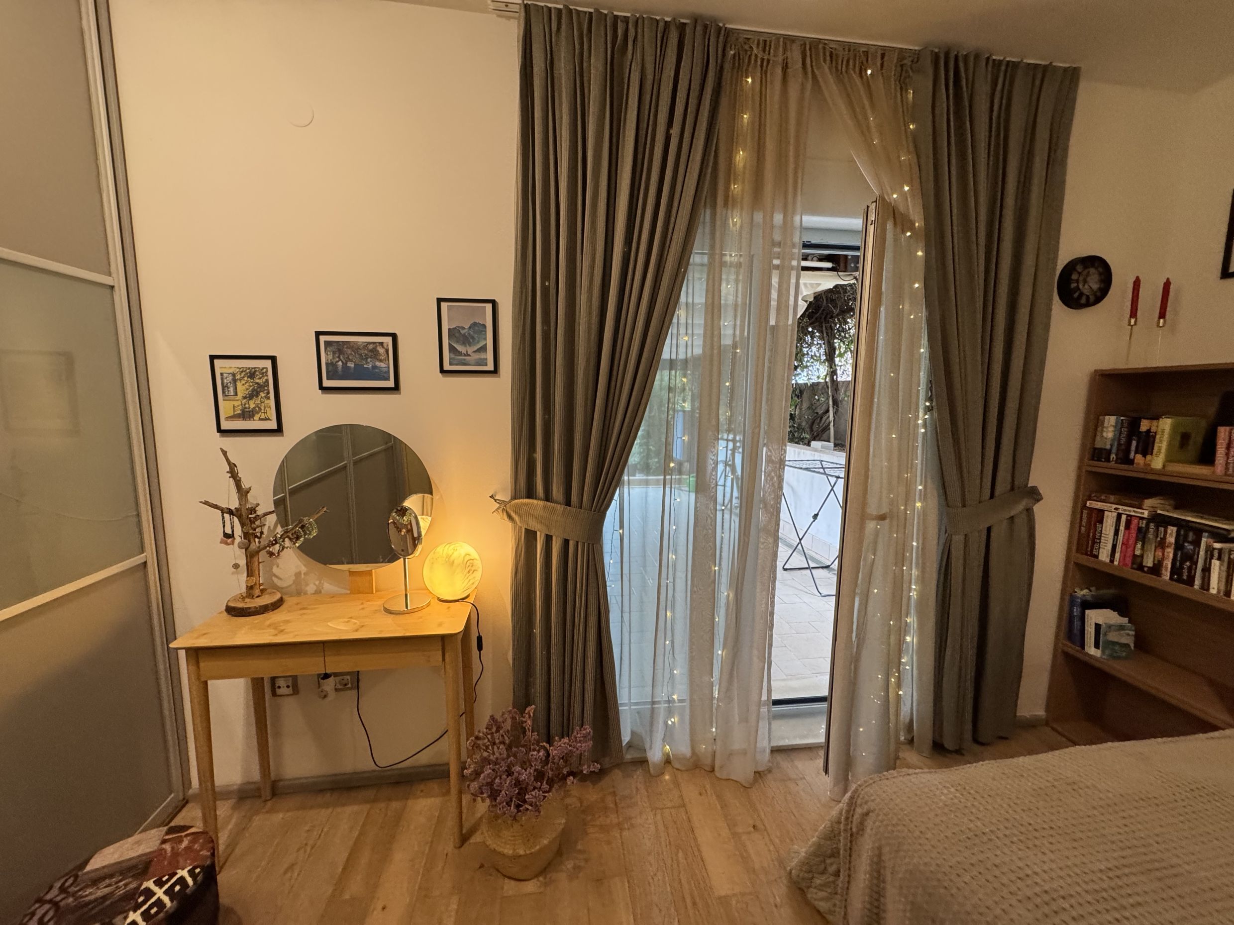 Cozy bedroom in an apartment in Dobrota, Montenegro: vanity table, bookcase, and access to a terrace with a view.
