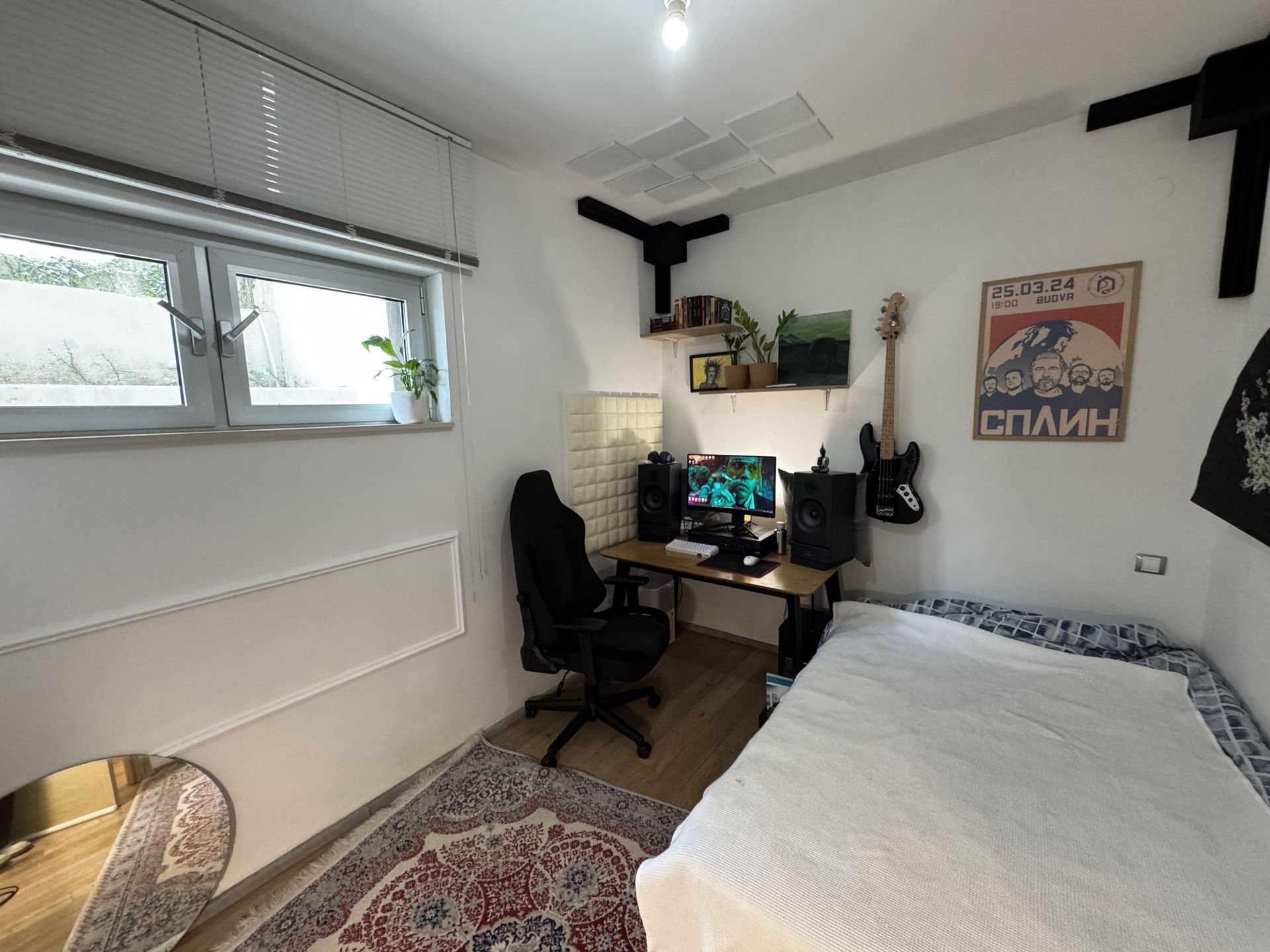 Cozy bedroom with a workspace in an apartment, Dobrota, Montenegro: bed, computer desk, and wall decor.