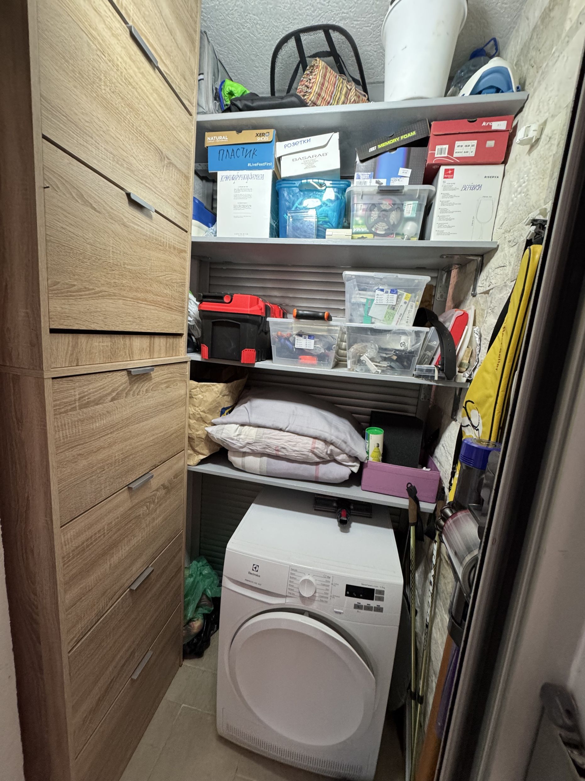 Utility room with a dryer and storage shelves in the apartment, Dobrota, Montenegro.