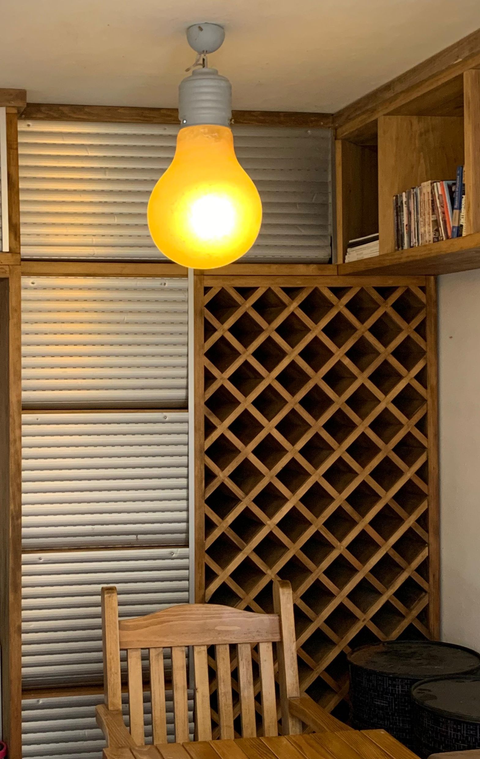 Living room interior in an apartment in Dobrota, Montenegro: a wooden wine rack, a stylish light fixture, and cozy furniture.
