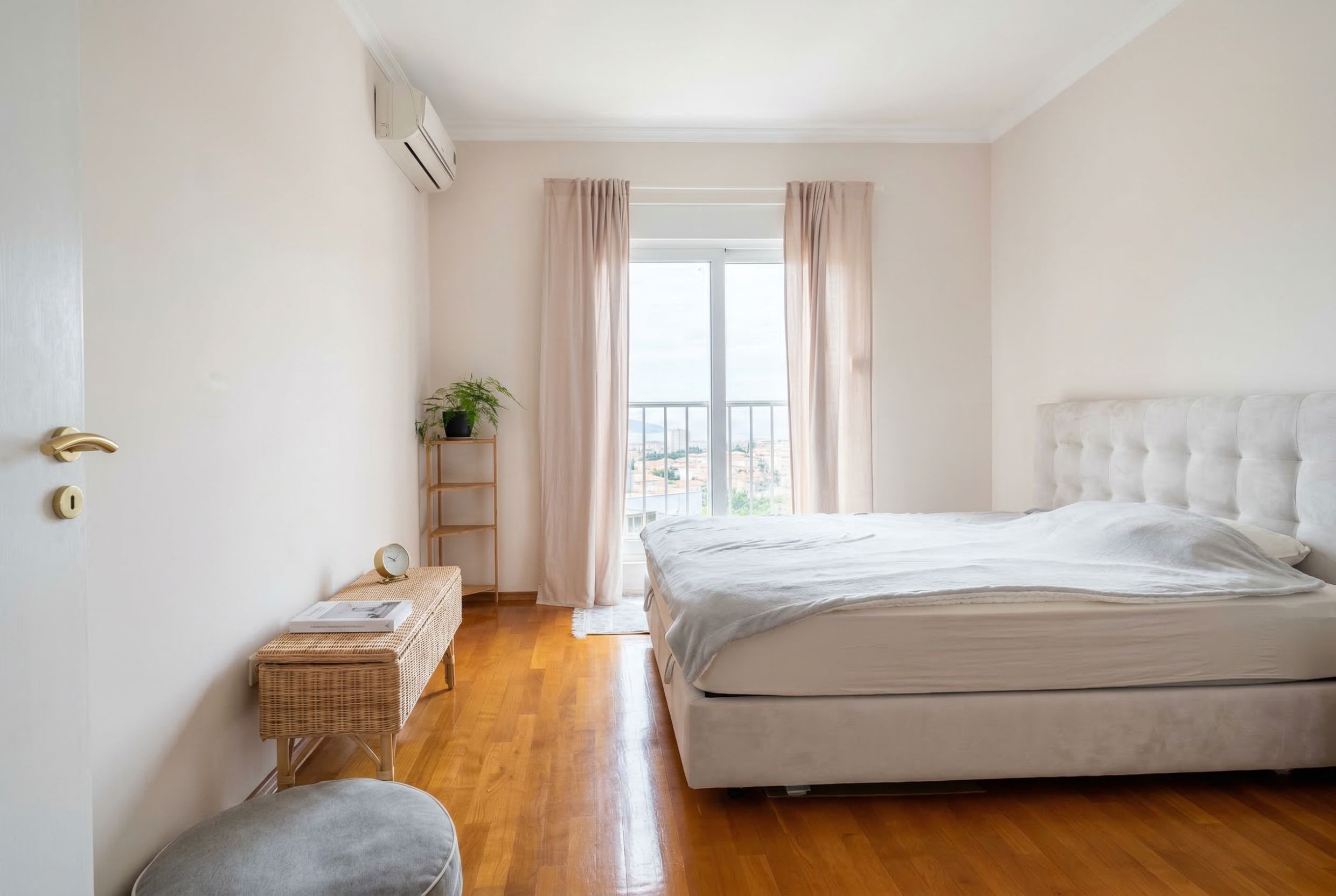 Bright bedroom with a double bed, parquet flooring, and access to the balcony in an apartment in Budva, Montenegro.
