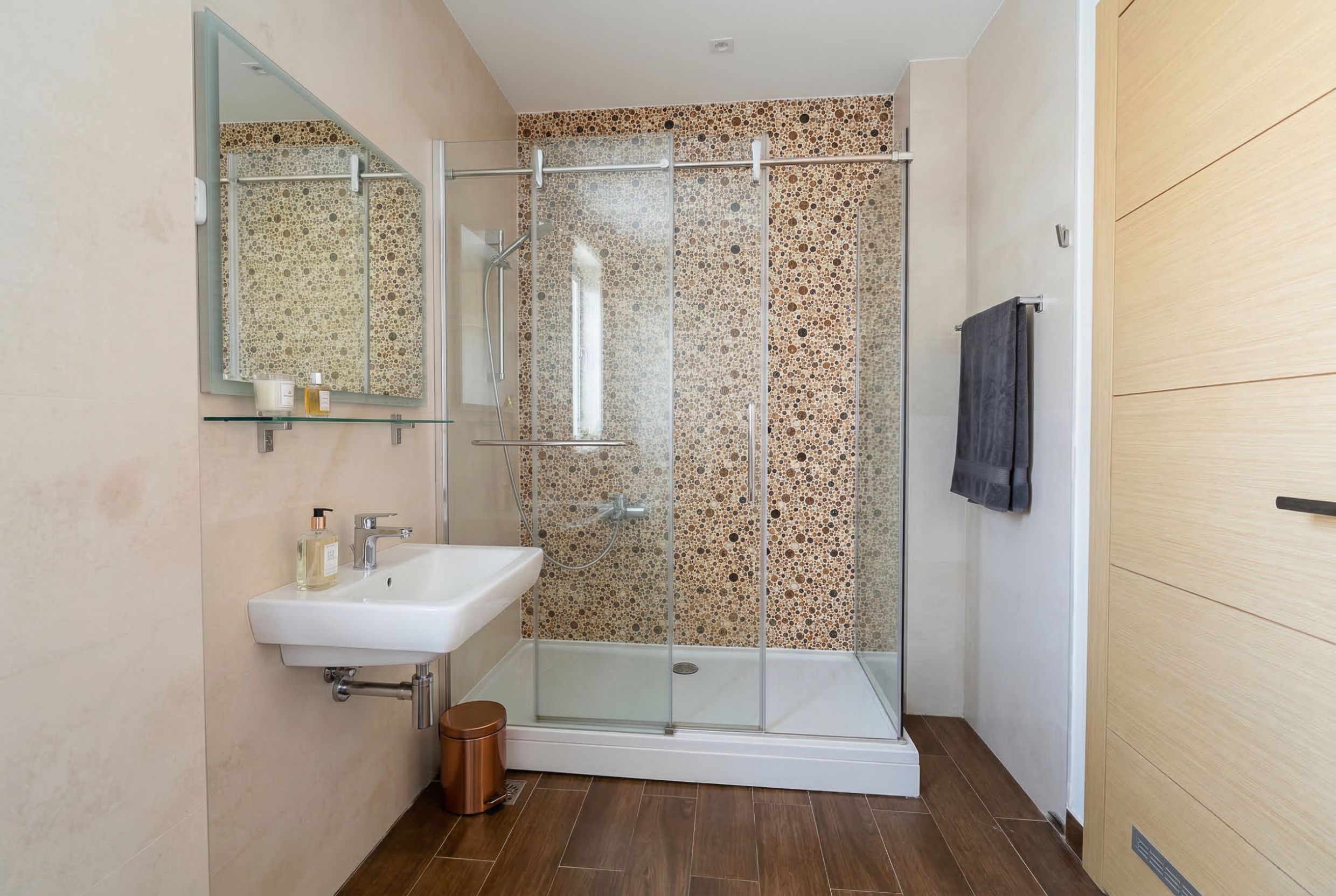 Modern bathroom with a shower cabin and mosaic tiles in an apartment in Budva, Montenegro.