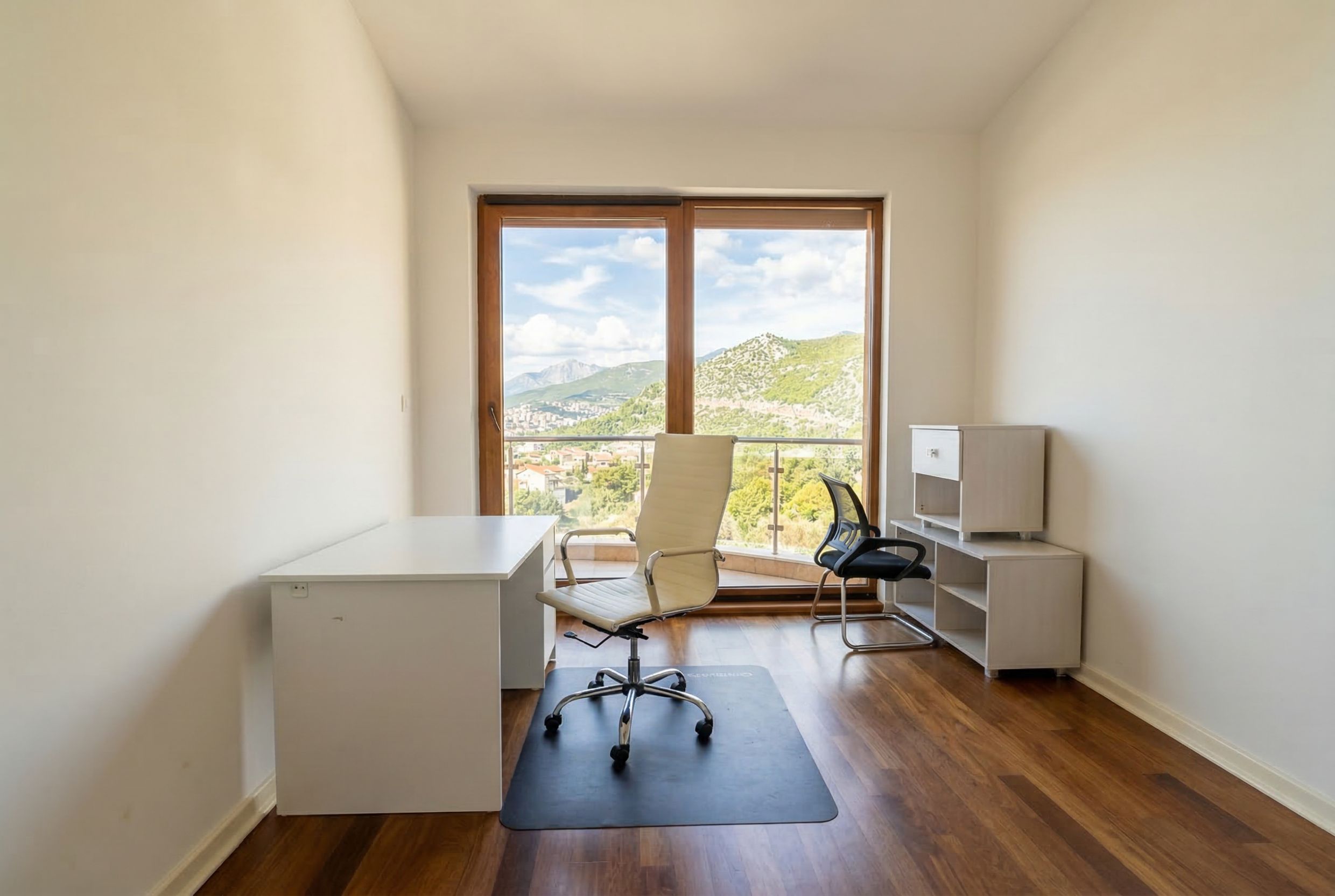 Office in a penthouse in Kamenovo, Montenegro: light furniture, parquet flooring, and panoramic mountain views.