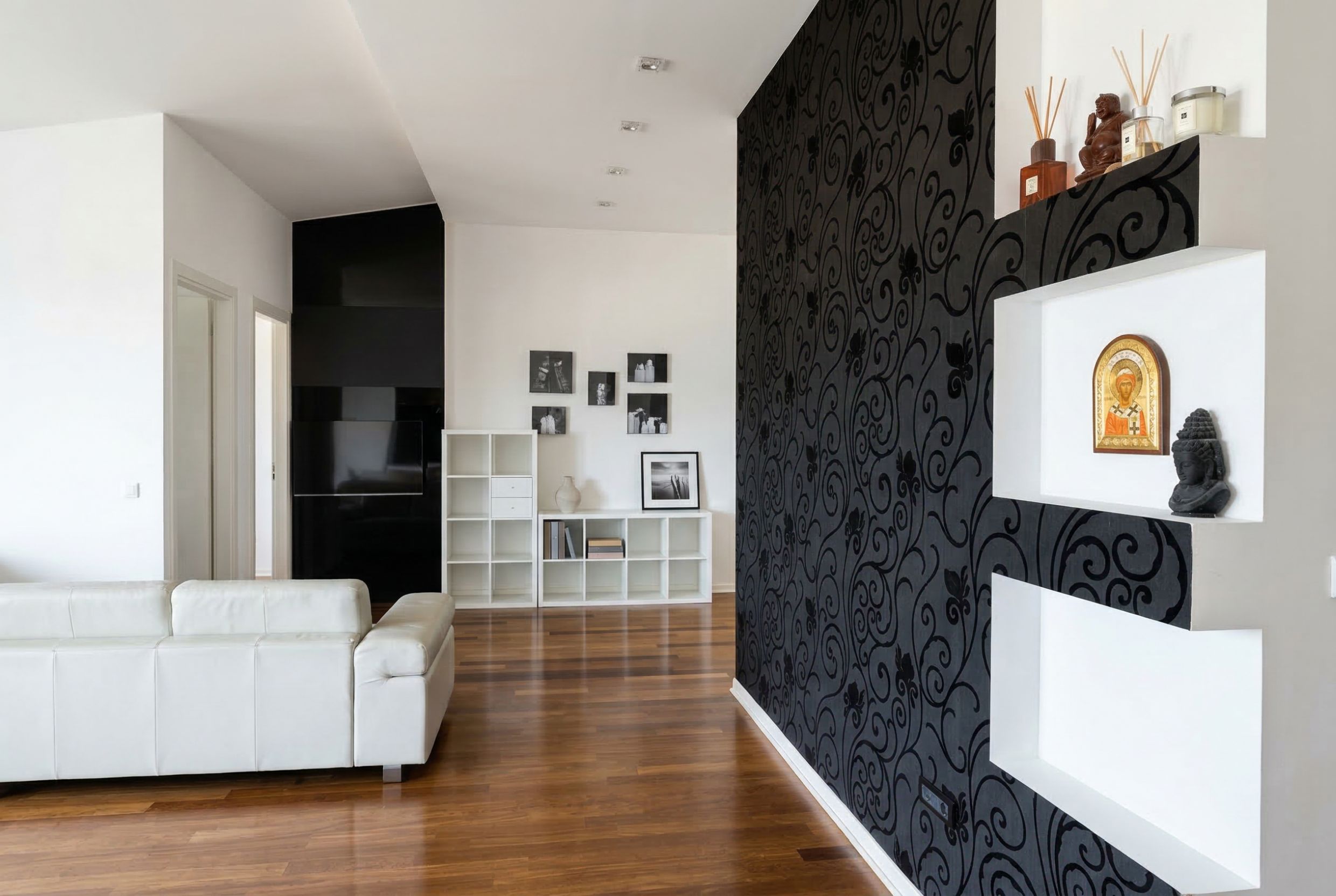 Penthouse living room in Kamenovo, Montenegro: white leather furniture, black patterned wallpaper, and wall niches.