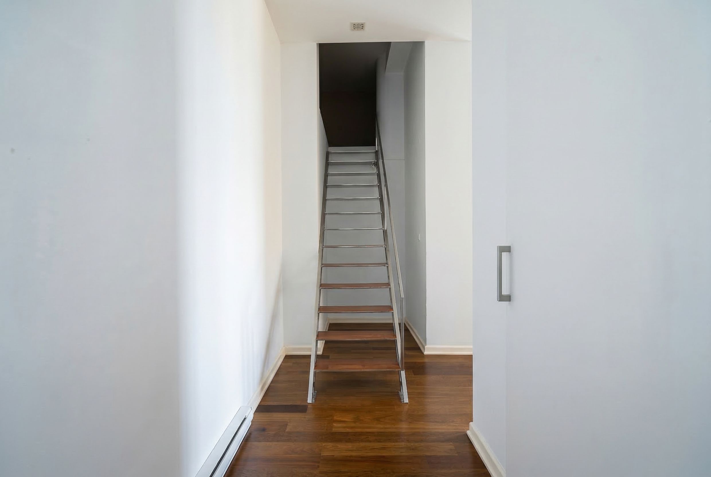 Modern staircase with wooden steps in the interior of a penthouse in Kamenovo, Montenegro, bright hallway design.