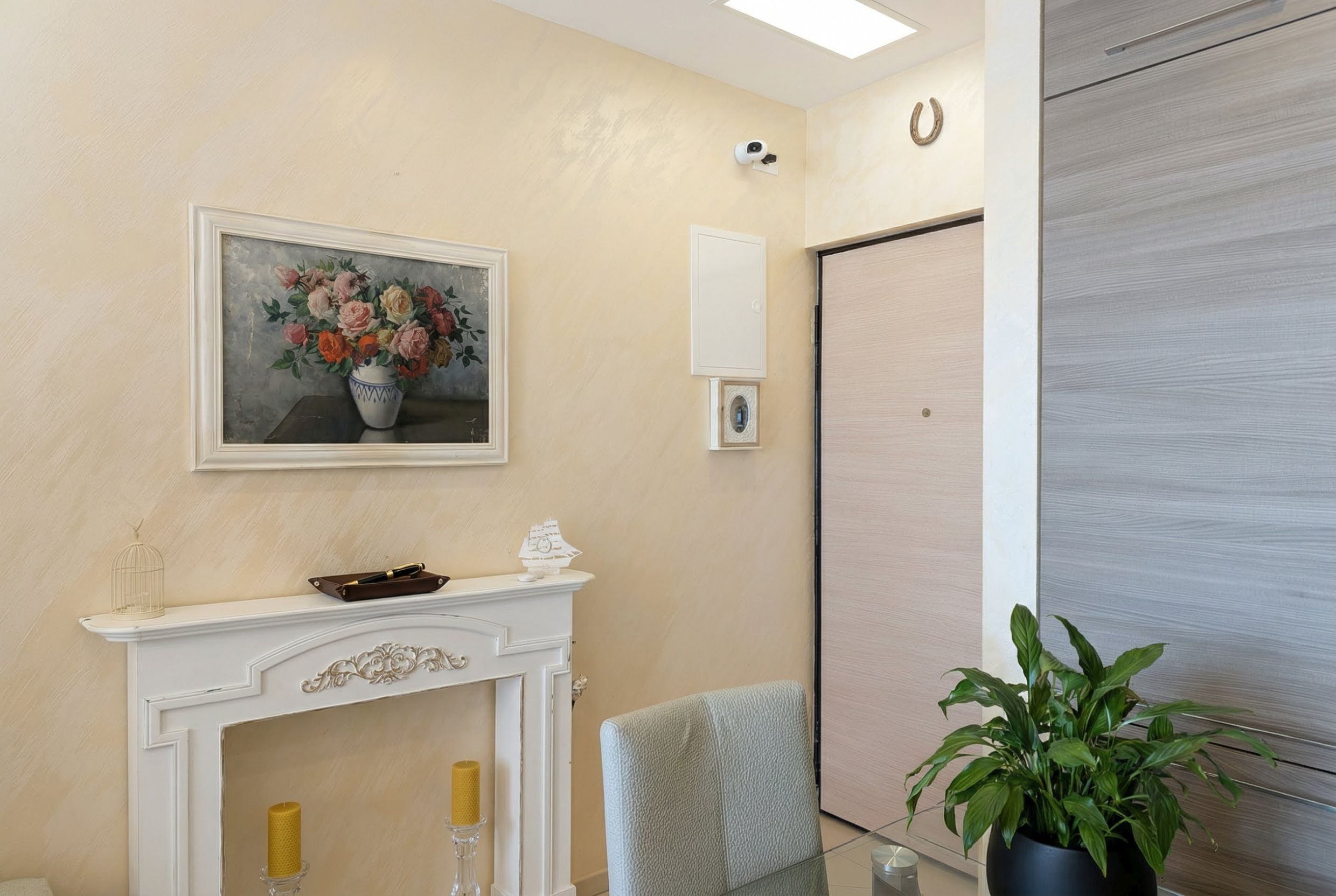 Living room interior in an apartment in Bečići, Montenegro: decorative fireplace, floral painting, and light wall finishes.