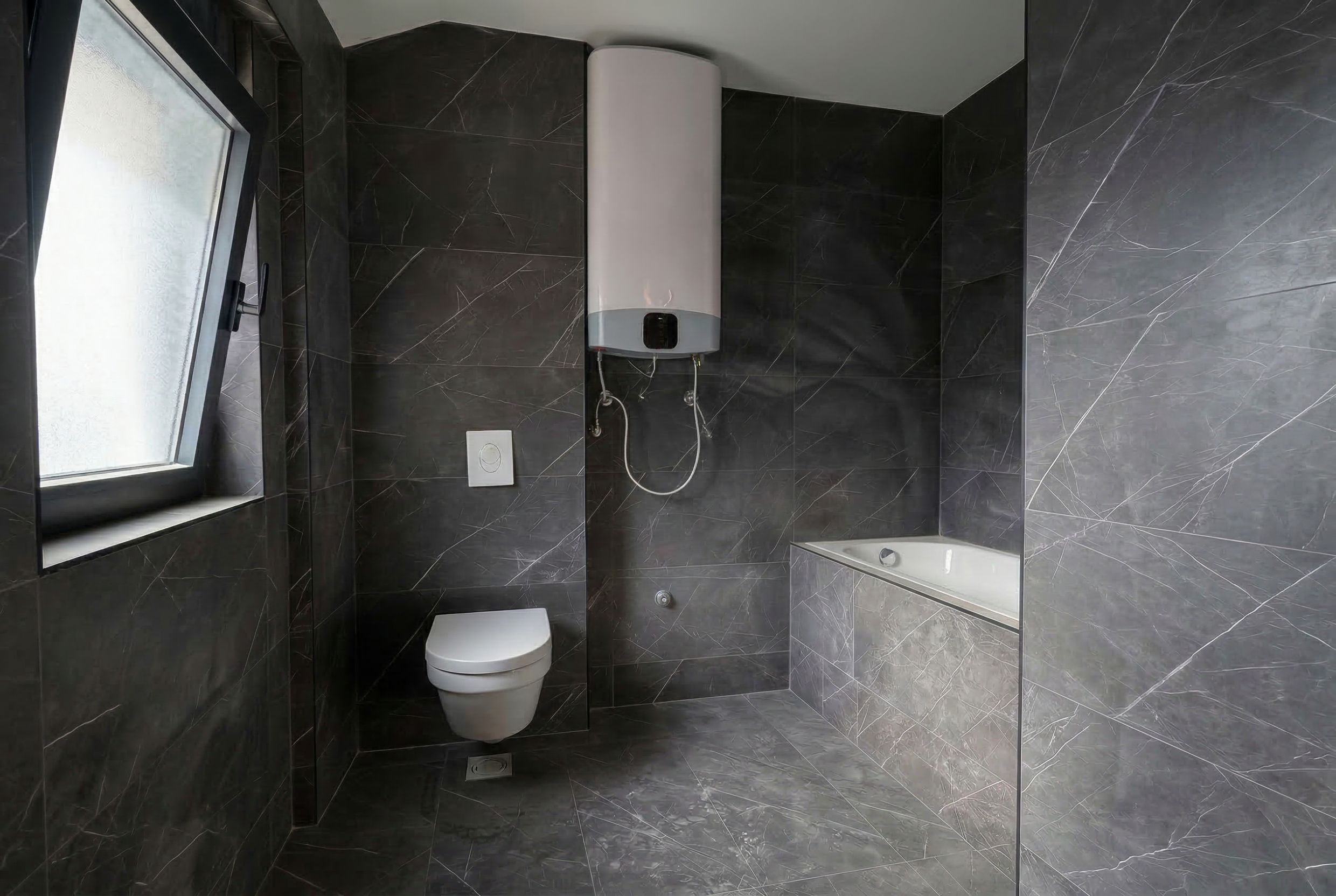 Modern bathroom in a penthouse in Budva, Montenegro: dark marble finishes, bathtub, and water heater.