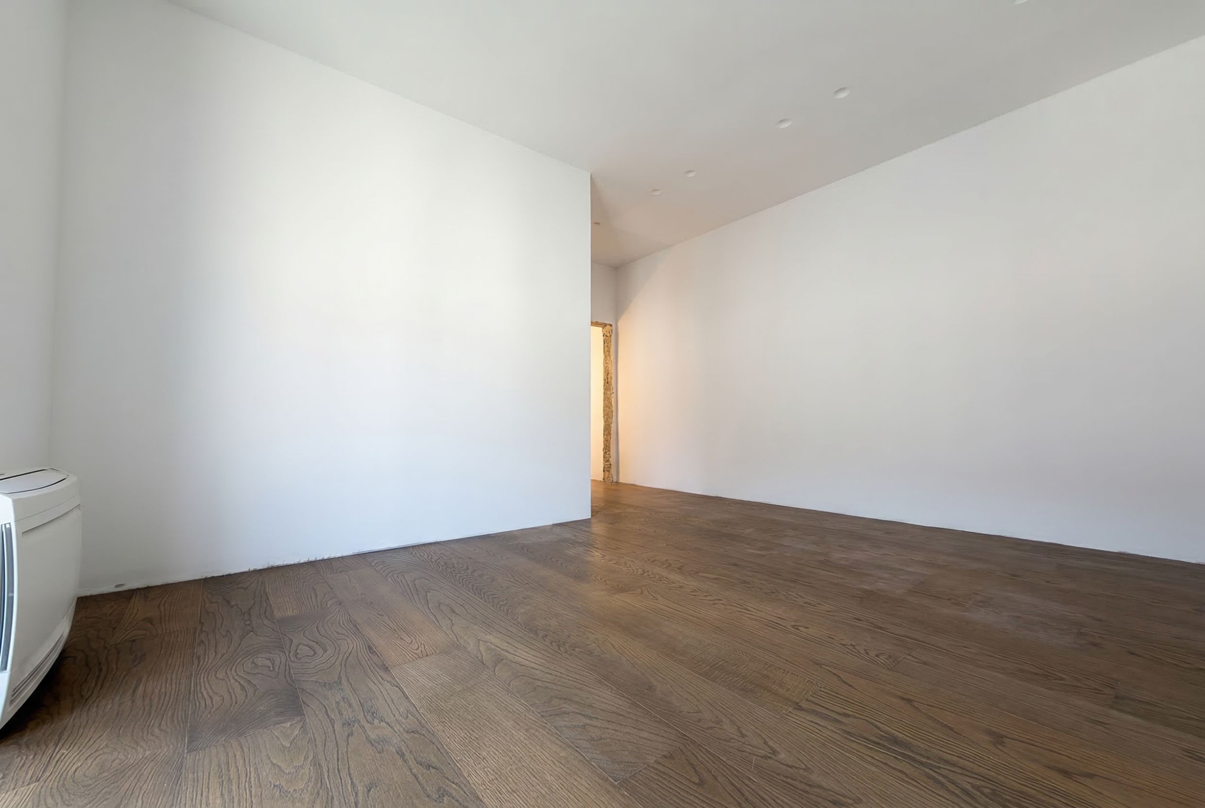 Bright living room with parquet flooring in a penthouse in Budva, Montenegro. Modern interior with white walls.