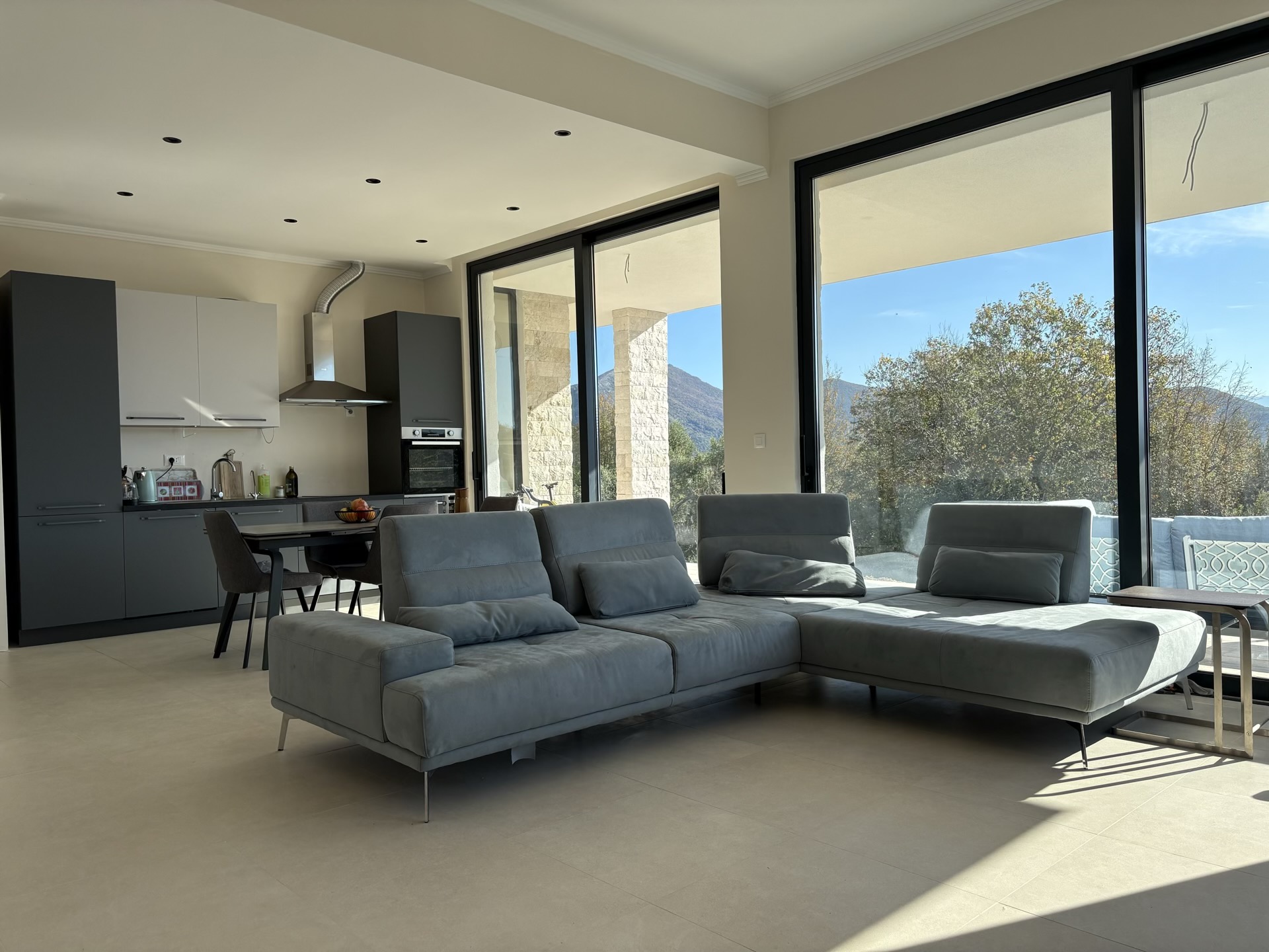 Modern living room with panoramic windows and kitchen in a villa in Herceg Novi, Montenegro: stylish interior with mountain views