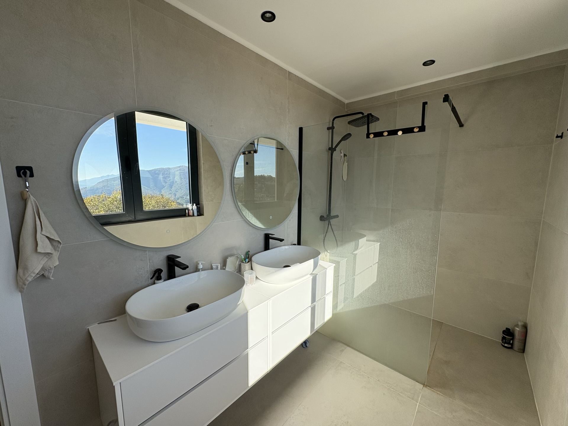 Modern bathroom with two sinks and mountain views in a residential complex, Herceg Novi, Montenegro.