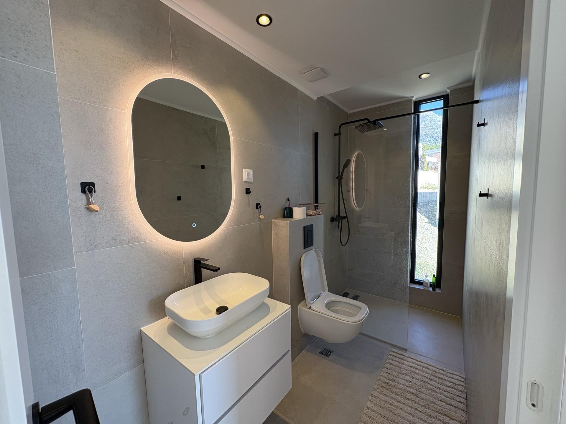 Modern bathroom with a shower cabin and mirror lighting in a residential complex, Herceg Novi, Montenegro.