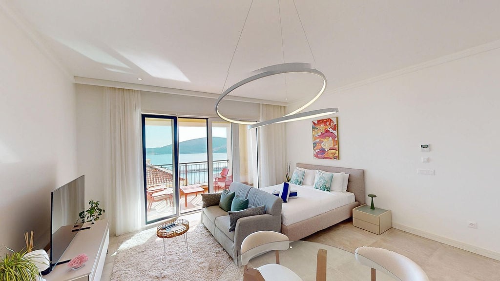 Modern living room with a bed and sea view in Luštica apartments, Montenegro: stylish furniture and terrace.
