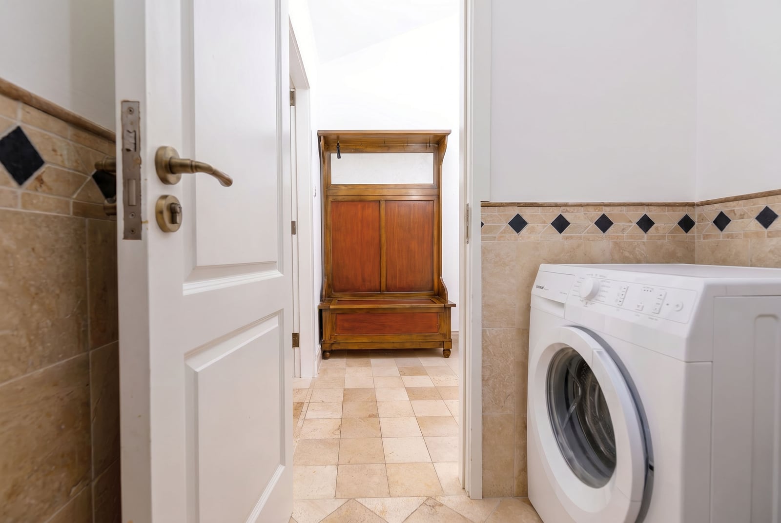 Bathroom with a washing machine and antique furniture in a penthouse, Risan, Montenegro. Bright interior.