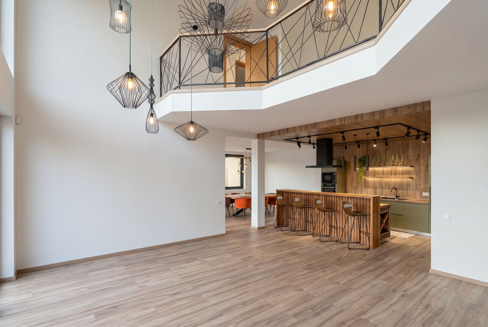 Living room interior with kitchen and bar counter in a villa in Kavac, Montenegro: modern design, double-height ceiling, and loft style.