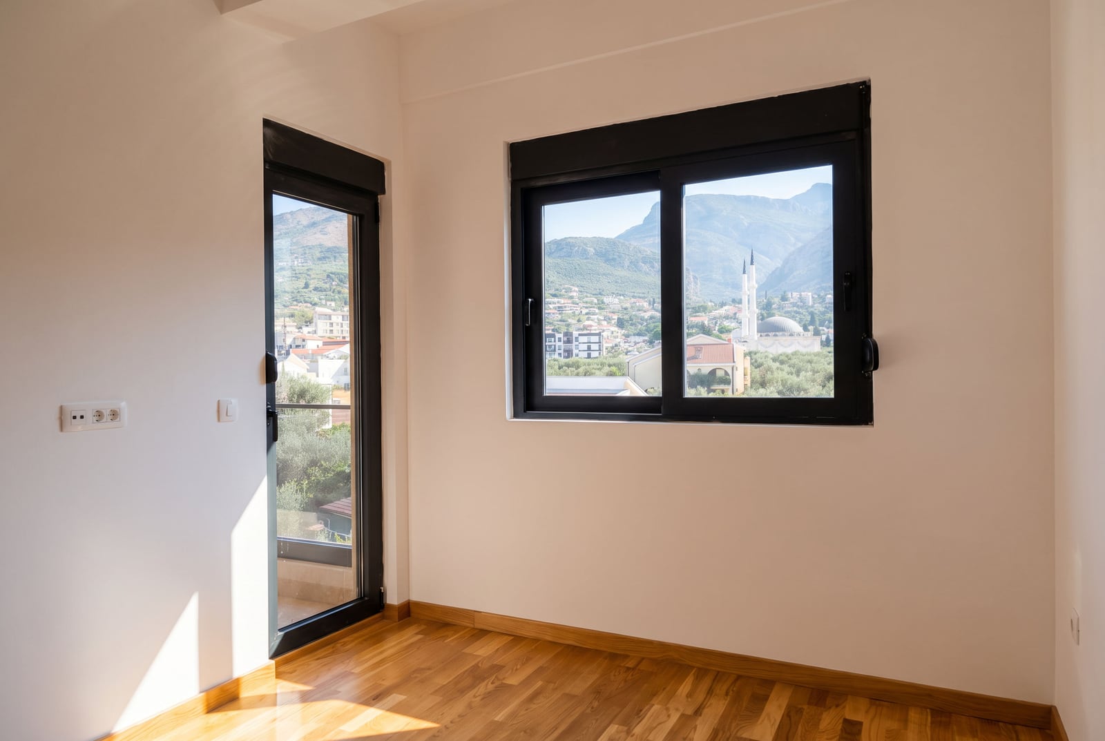 Bright bedroom with parquet flooring and panoramic mountain views in an apartment in Bar, Montenegro.