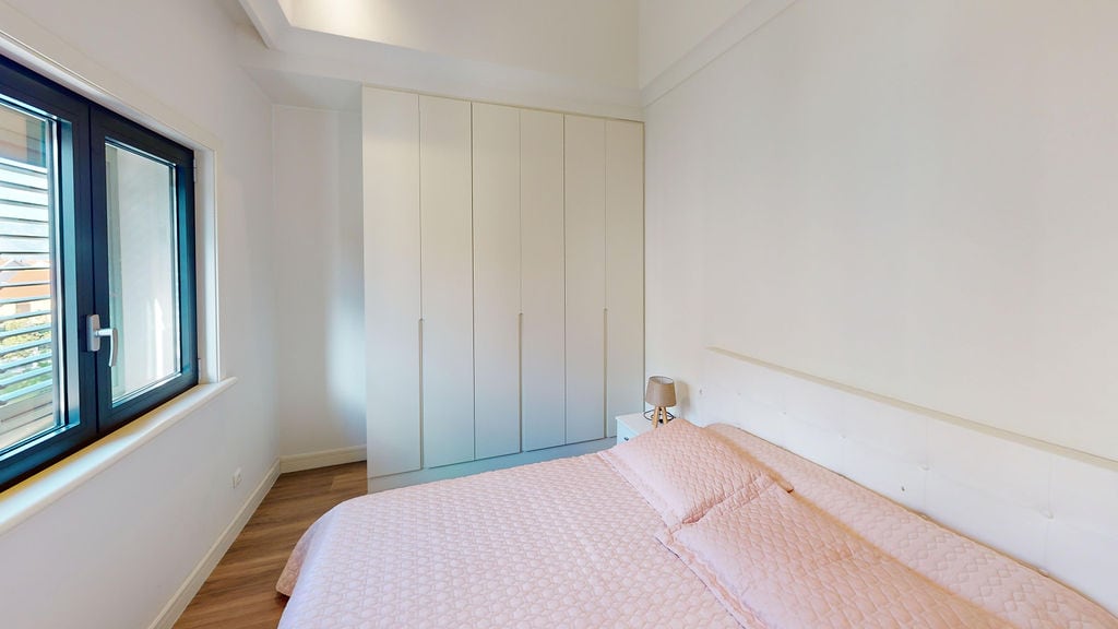 Bright bedroom with a double bed and built-in wardrobe in an apartment, Luštica, Montenegro.