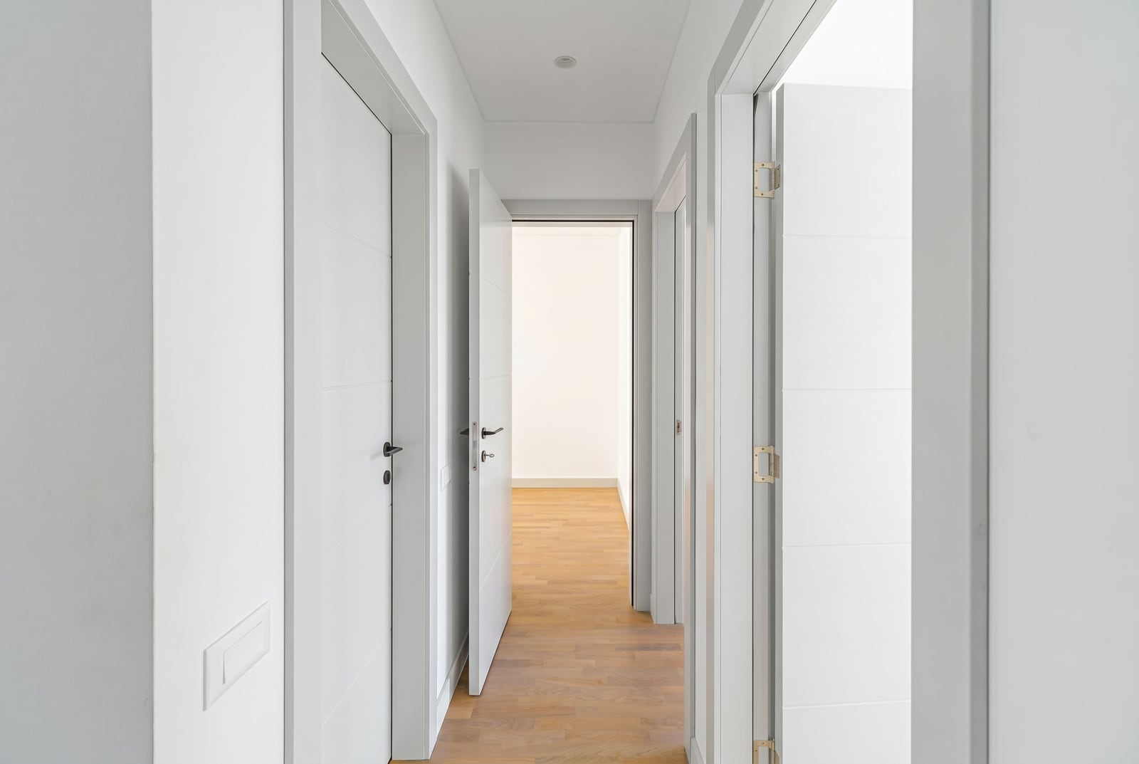 Bright hallway with white interior doors and parquet flooring in a townhouse, Kavac, Montenegro.