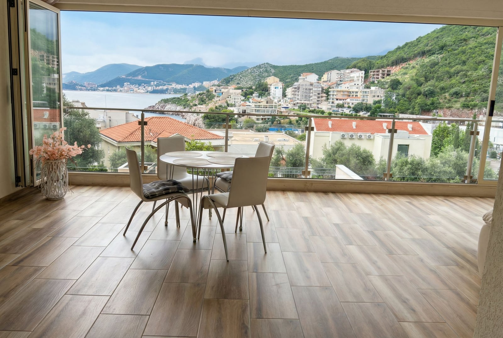 Terrace with a dining area and panoramic views of the sea and mountains in an apartment, Pržno, Montenegro.