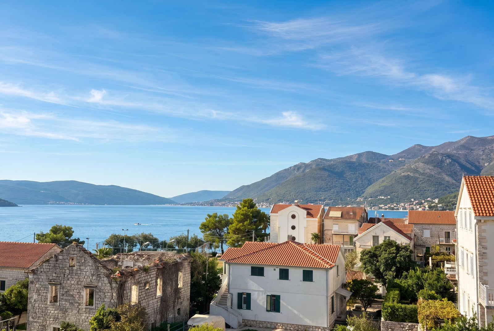 Panoramic view of the sea, mountains, and tiled rooftops in Tivat, Montenegro