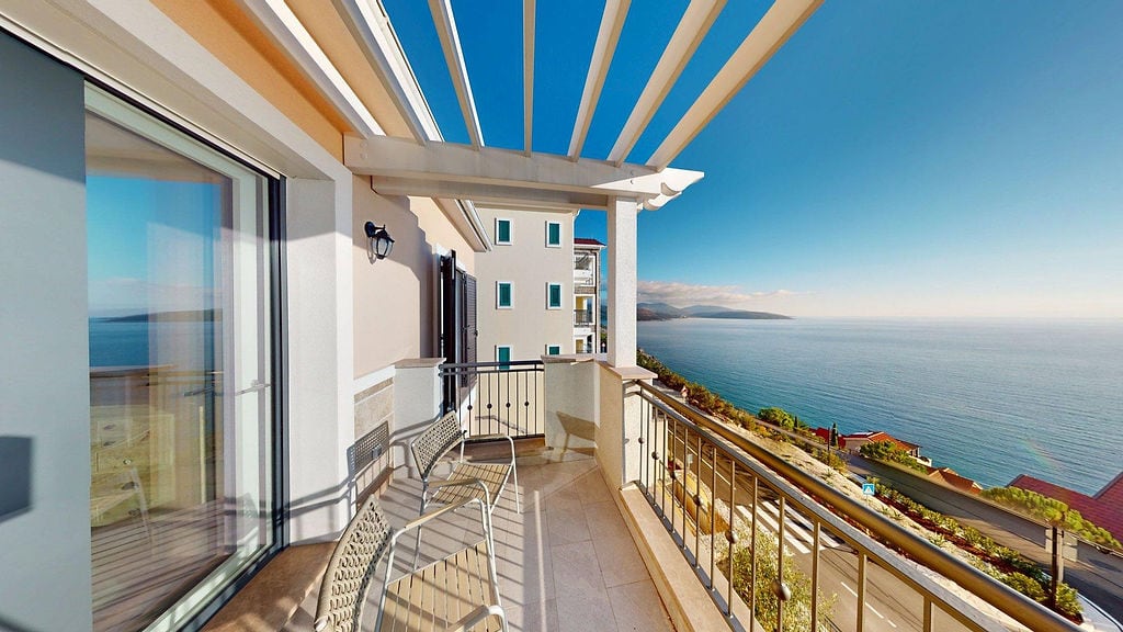 Terrace with a pergola and sea view in the Lustica Bay apartments, Montenegro. Furnished balcony with panoramic views.