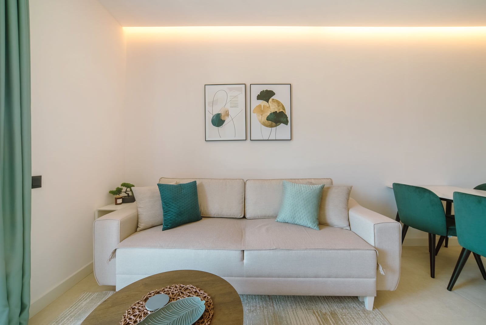 Modern living room with a beige sofa and green accents in an apartment at the Bečići residential complex, Montenegro.