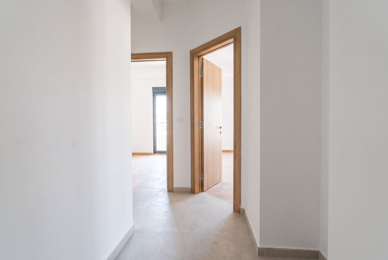 Bright hallway with white walls and wooden interior doors in an apartment in Bar, Montenegro