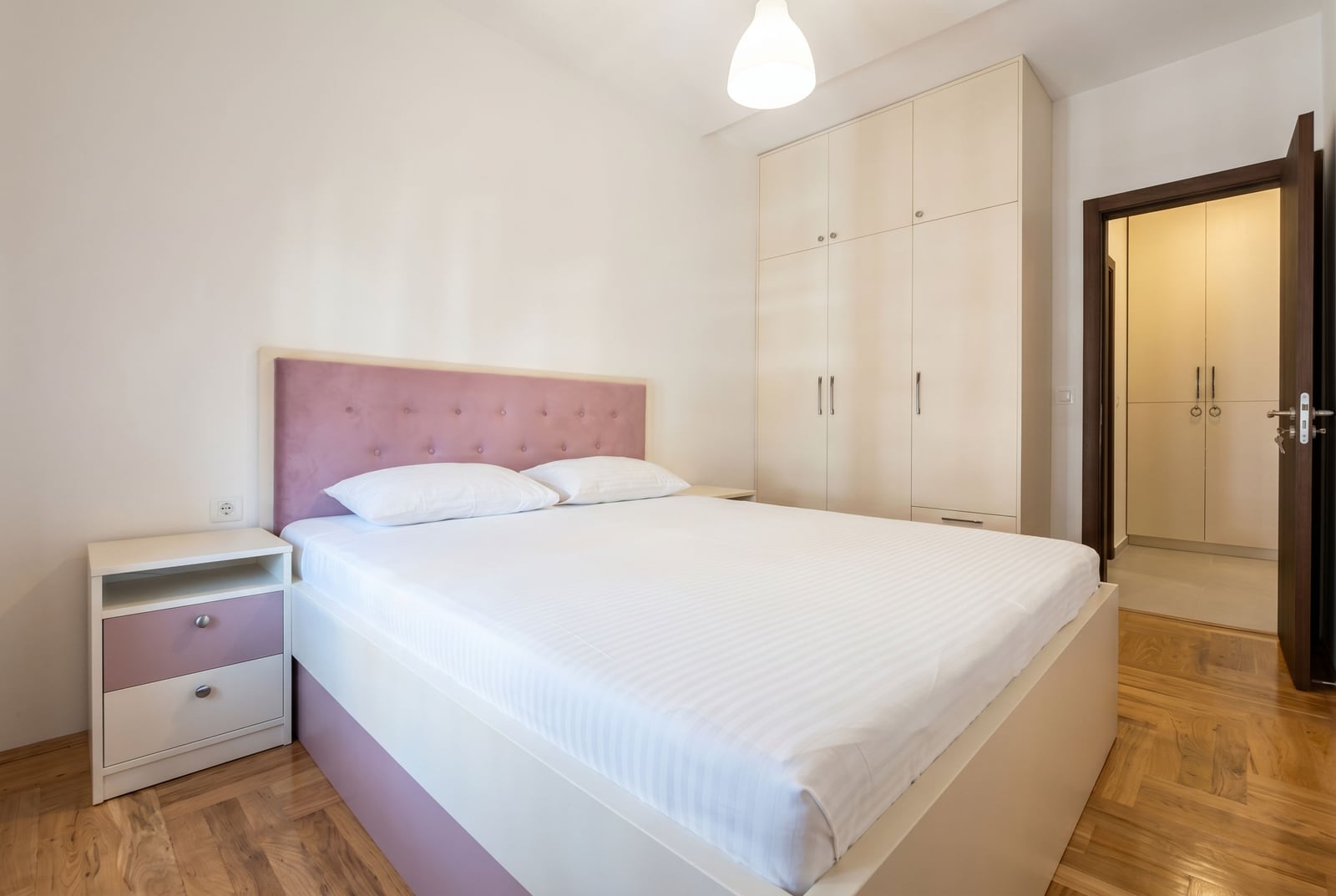 Bright bedroom with a double bed and a built-in wardrobe in an apartment, Rafailovici, Montenegro.