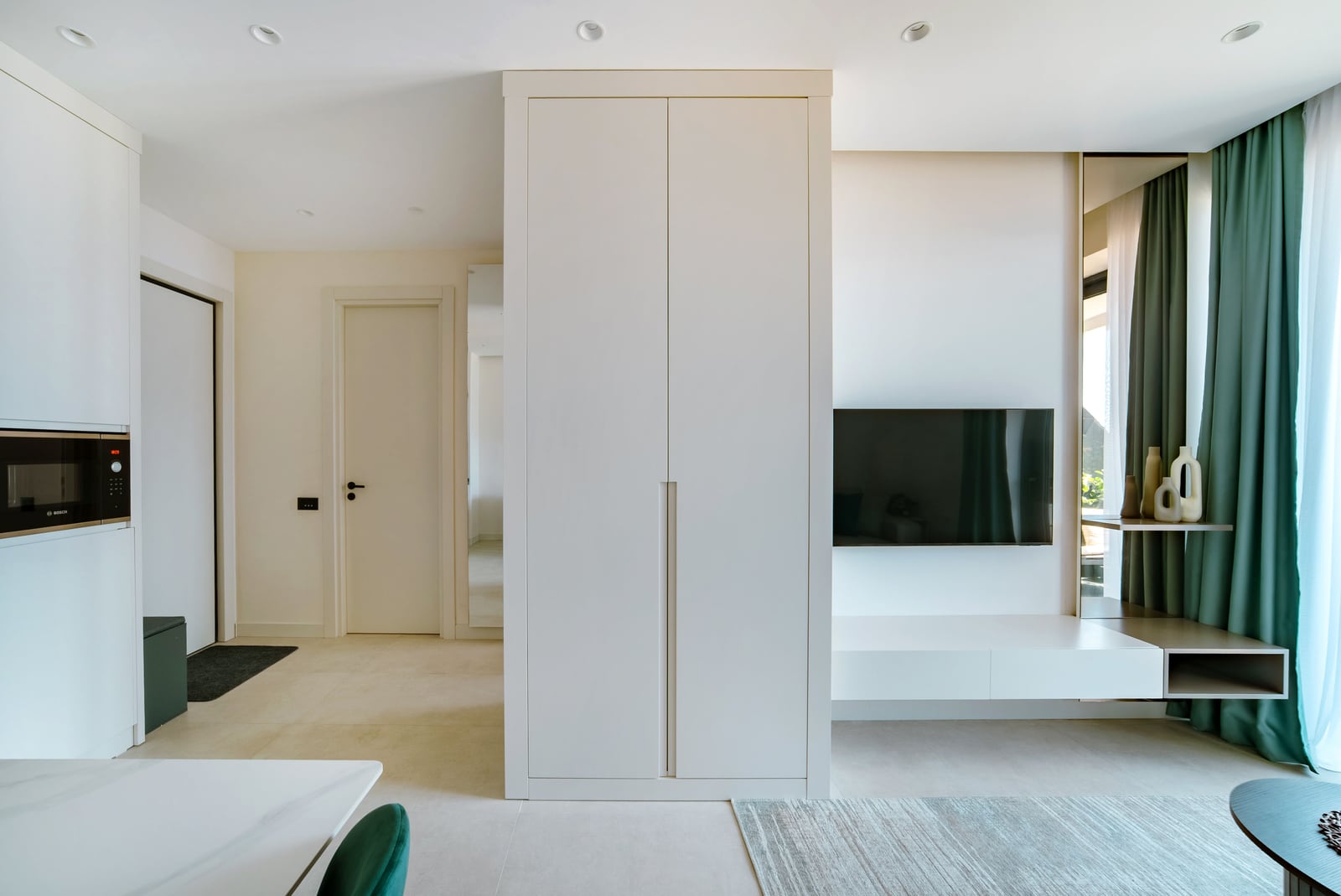 Modern living room in an apartment in Bečići, Montenegro: built-in wardrobe, TV area, and stylish interior in light tones.