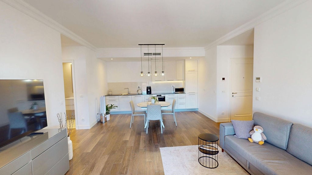 Modern living room with kitchen in an apartment, Luštica, Montenegro: bright interior, dining area, and a soft sofa.