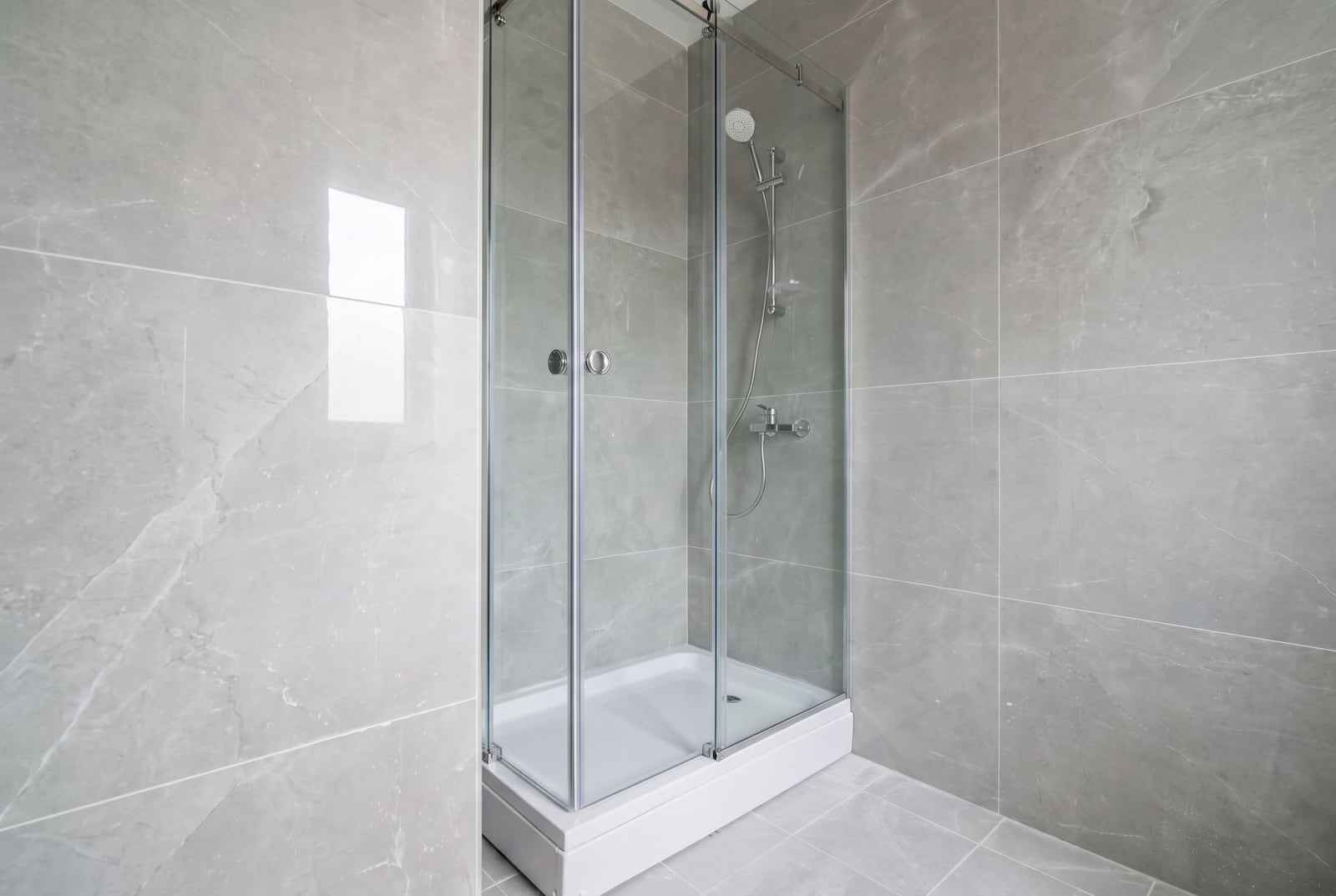 Modern shower cabin with gray ceramic tile finish in the bathroom of an apartment, Bar, Montenegro