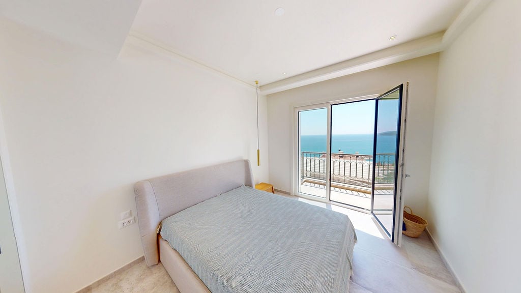 Bright bedroom with a double bed and panoramic sea view in a residential complex, Luštica, Montenegro.