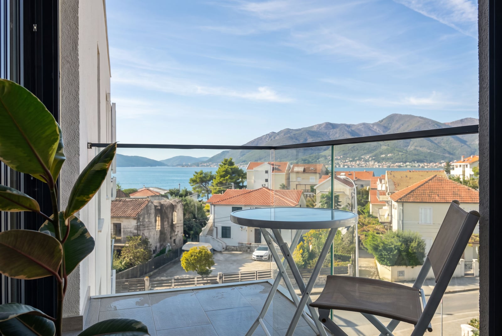 Balcony with furniture and panoramic view of the sea and mountains in Tivat, Montenegro