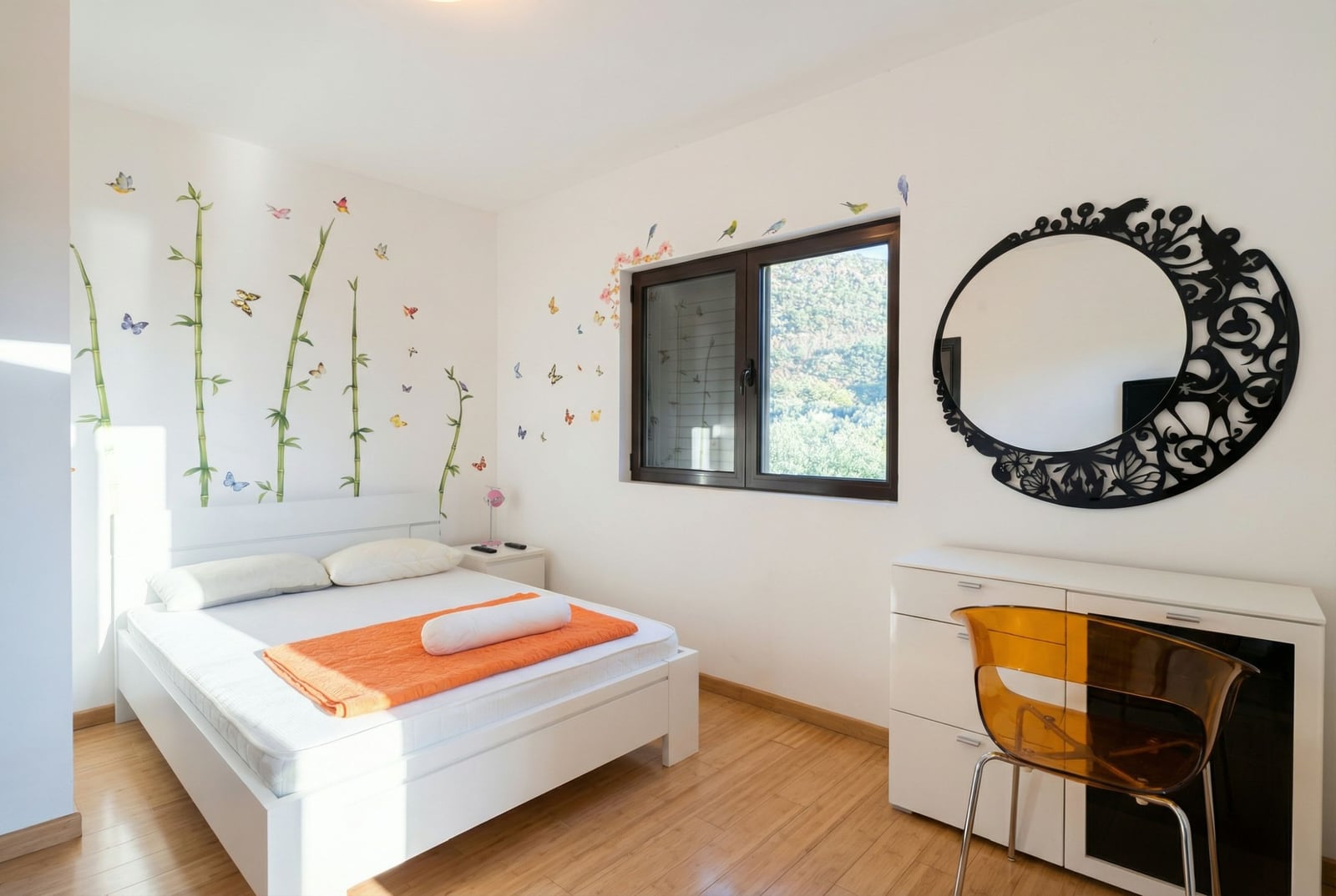 Bright bedroom with a double bed and mountain view in an apartment, Becici, Montenegro: wall decor and a stylish mirror.