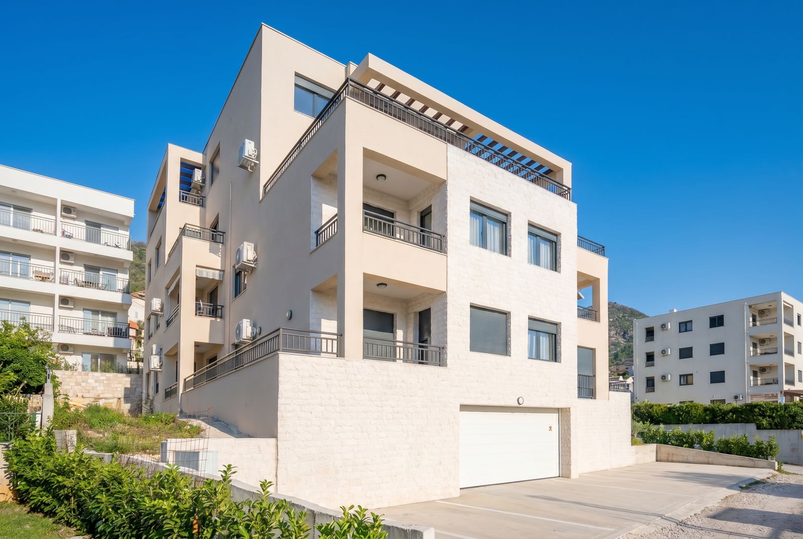 Modern residential building with terraces and a garage in Tivat, Montenegro: building facade with stone finish.