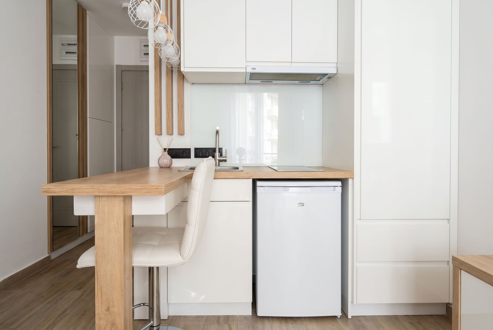 Modern white kitchen with a breakfast bar in a residential complex apartment in Bečići, Montenegro: built-in appliances and bright design.