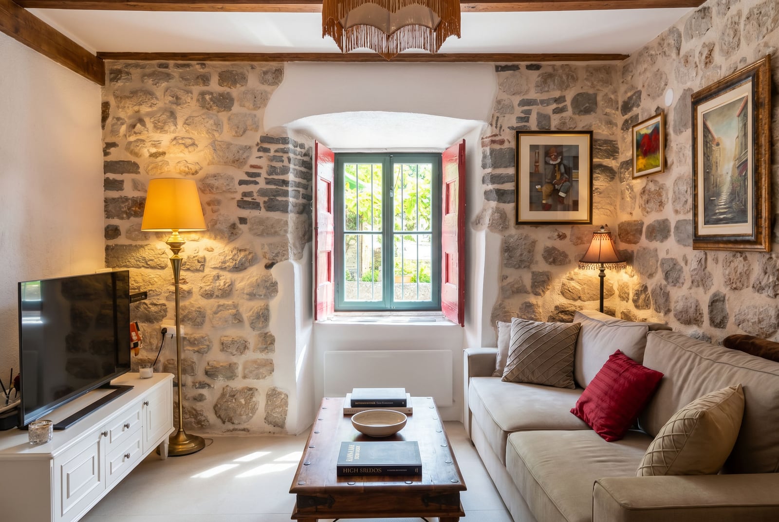 Cozy living room in a stone house in Dobrota, Montenegro: interior featuring natural stone finishes and upholstered furniture.