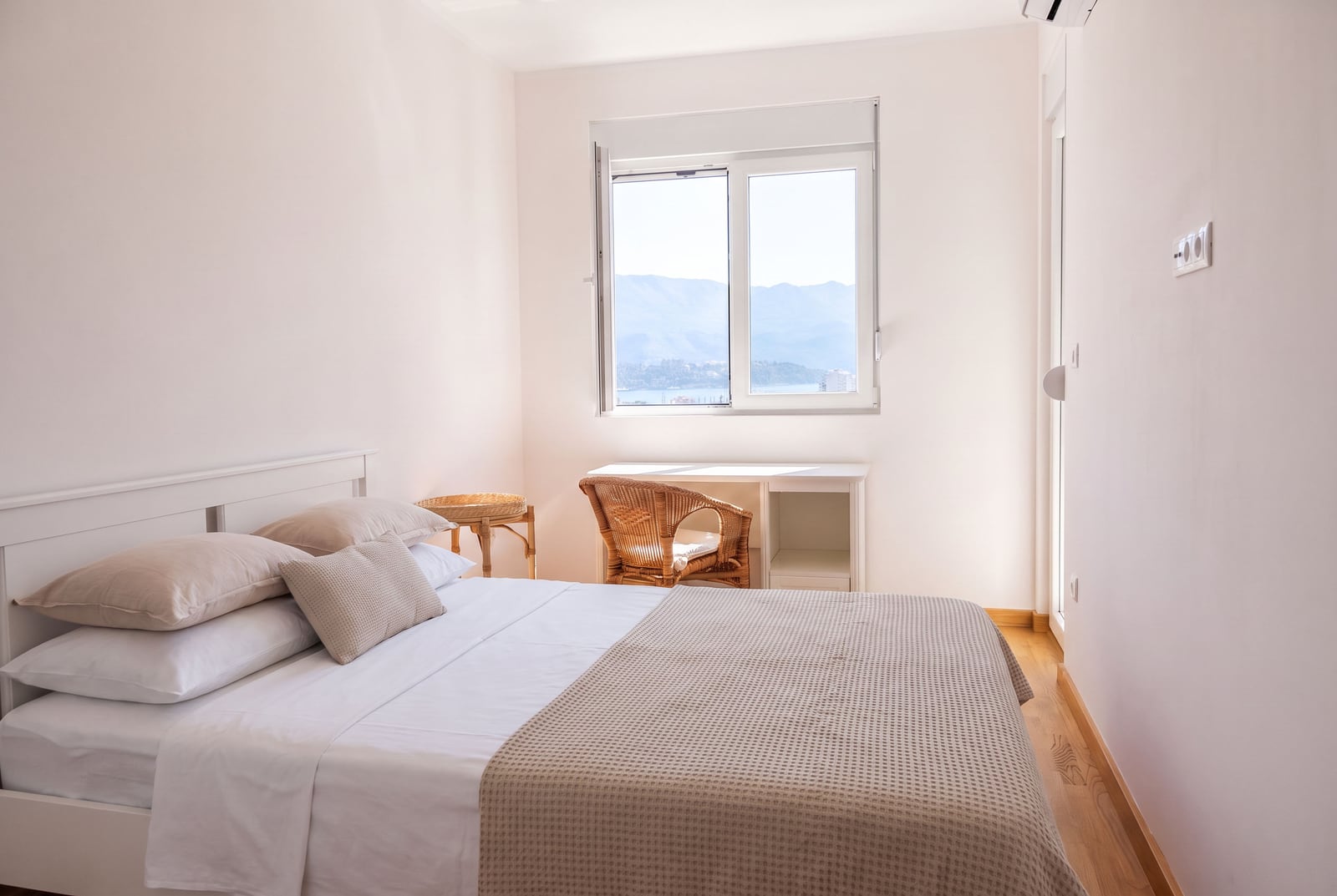 Bright bedroom with a double bed and a sea view in an apartment in Budva, Montenegro. Modern interior.