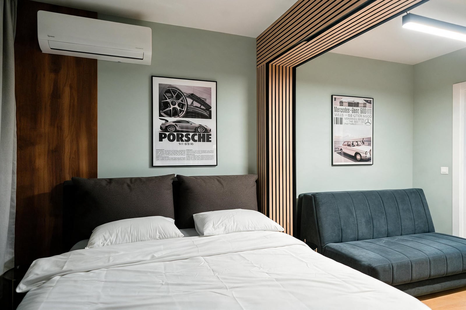 Modern bedroom featuring a white bed, blue sofa, and automotive posters on light green walls with wood accents.