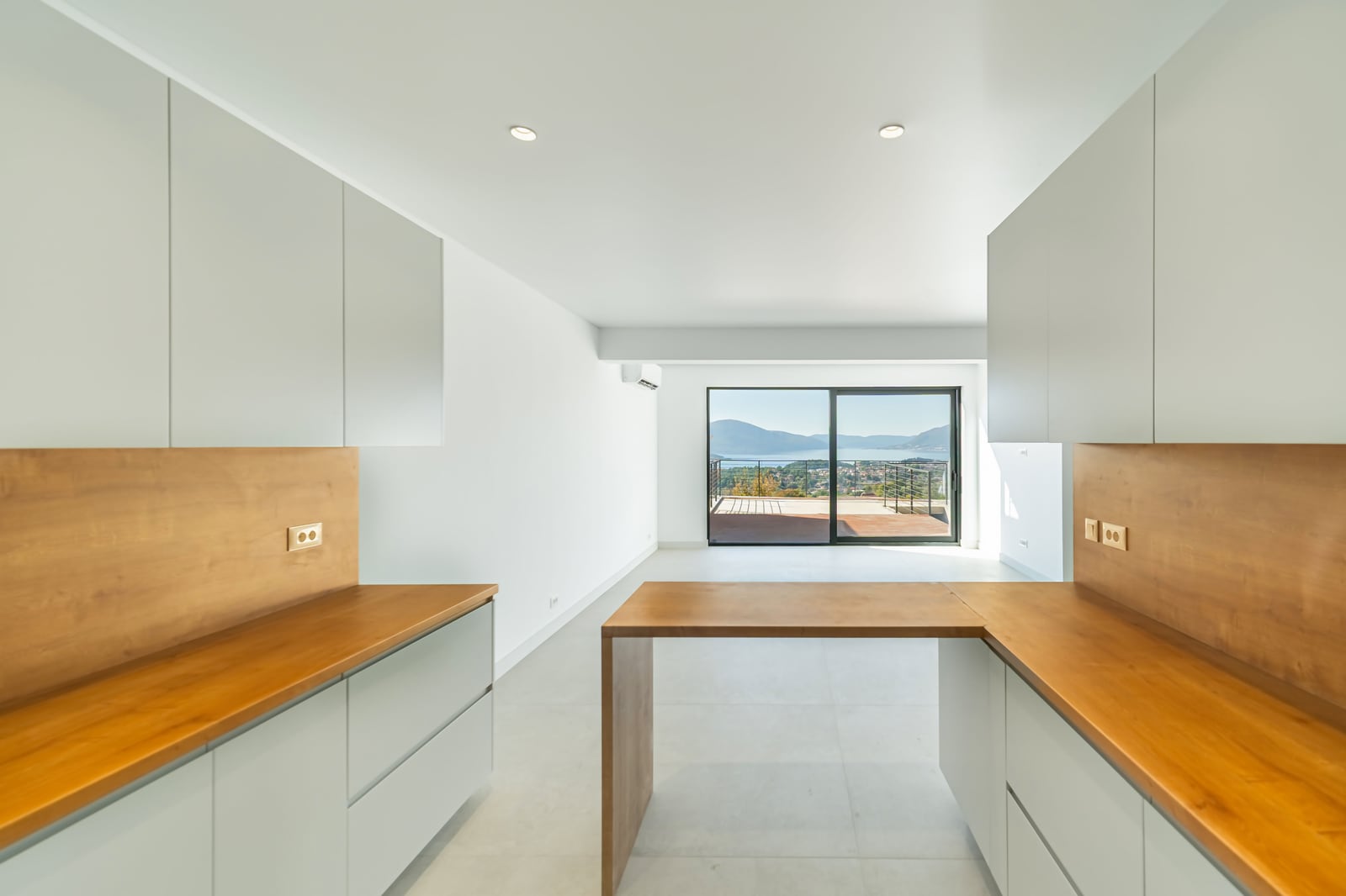 Modern kitchen in a townhouse, Kavač, Montenegro: light-colored cabinets, wooden countertops, and panoramic sea views.