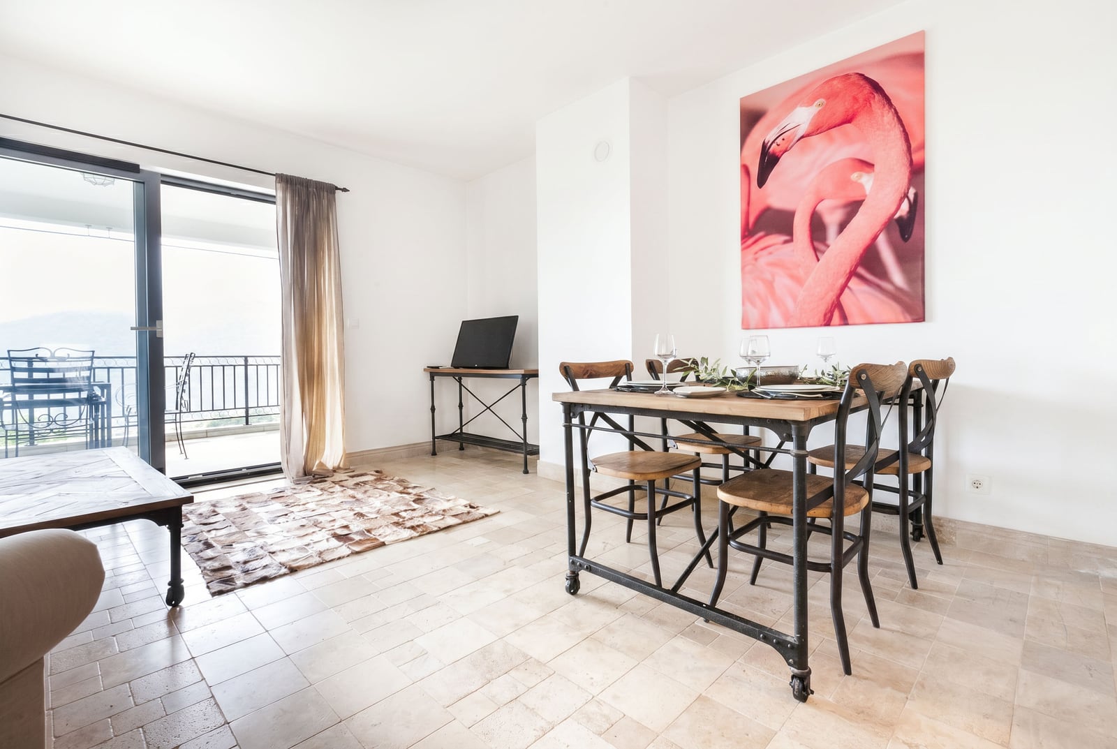 Bright living room with a dining area and access to the terrace in an apartment, Risan, Montenegro. Modern loft-style furniture.