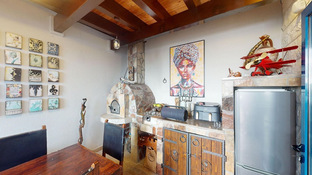 Kitchen in a townhouse in Luštica, Montenegro: stone oven, wooden beams, decor, and stylish interior finishes.
