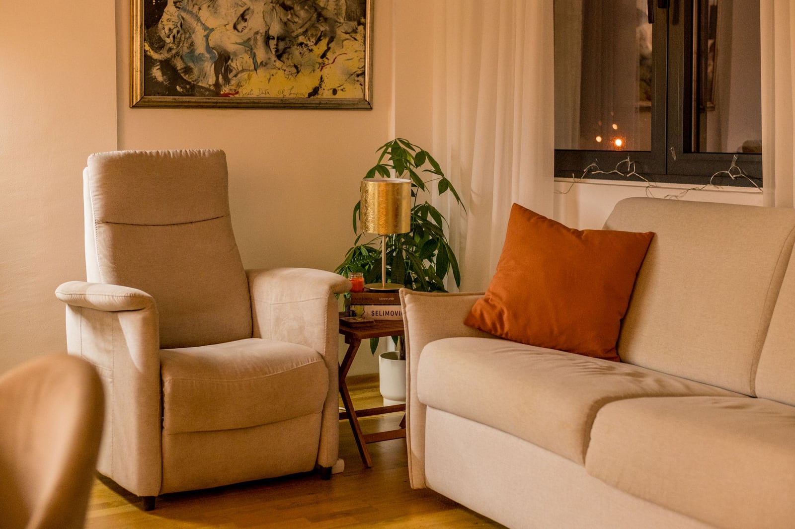 Cozy living room in an apartment in Tivat, Montenegro: beige sofa, armchair, coffee table, and interior decor.