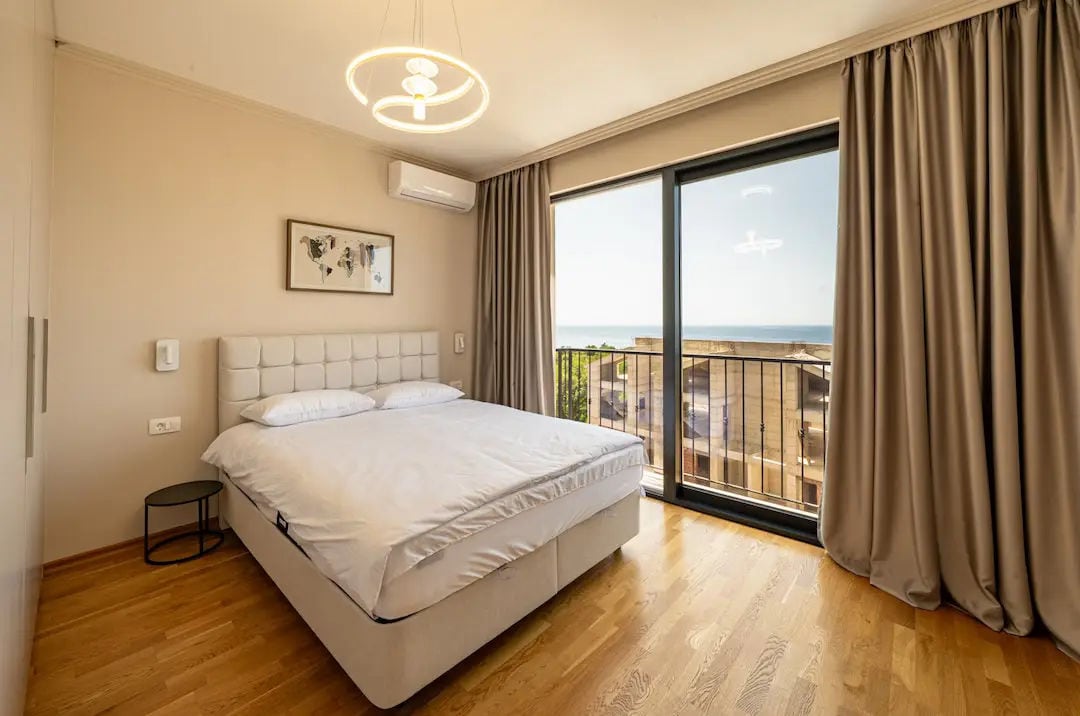 Bedroom with a double bed and panoramic sea views in a villa in Reževići, Montenegro. Modern interior.