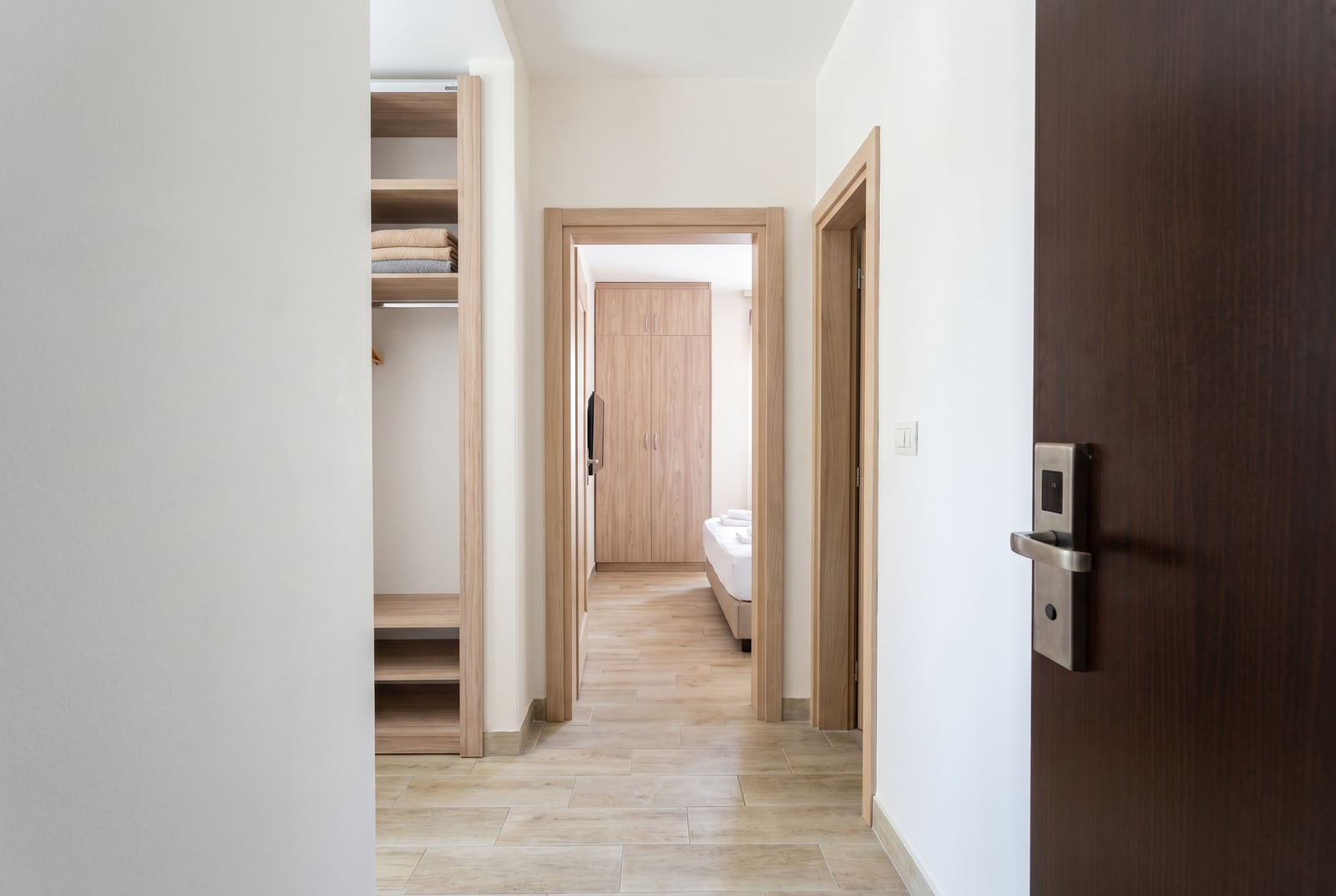 Interior of hallway and bedroom with wooden furniture in a modern apartment, Bečići, Montenegro.