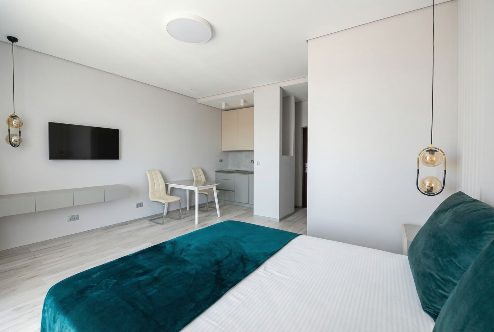 Modern bedroom with kitchen in an apartment, Becici, Montenegro: double bed, dining area, and stylish interior.