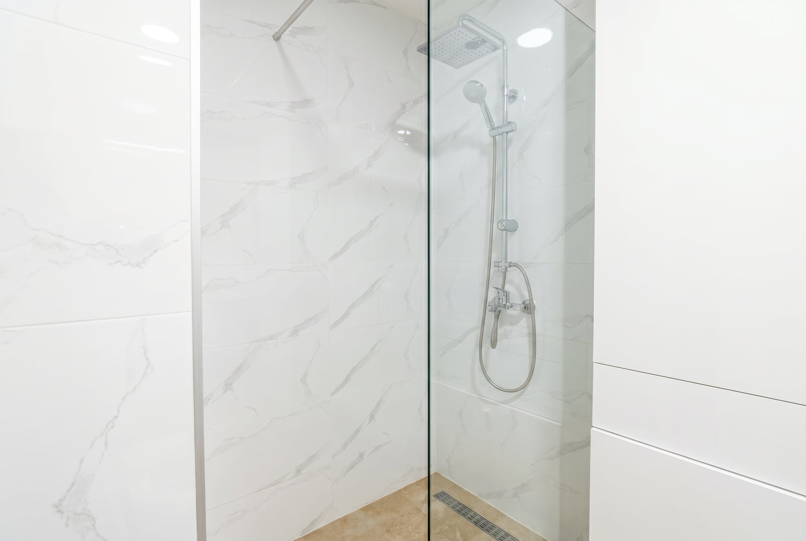Modern shower cabin with white marble finish in an apartment in Bečići, Montenegro.
