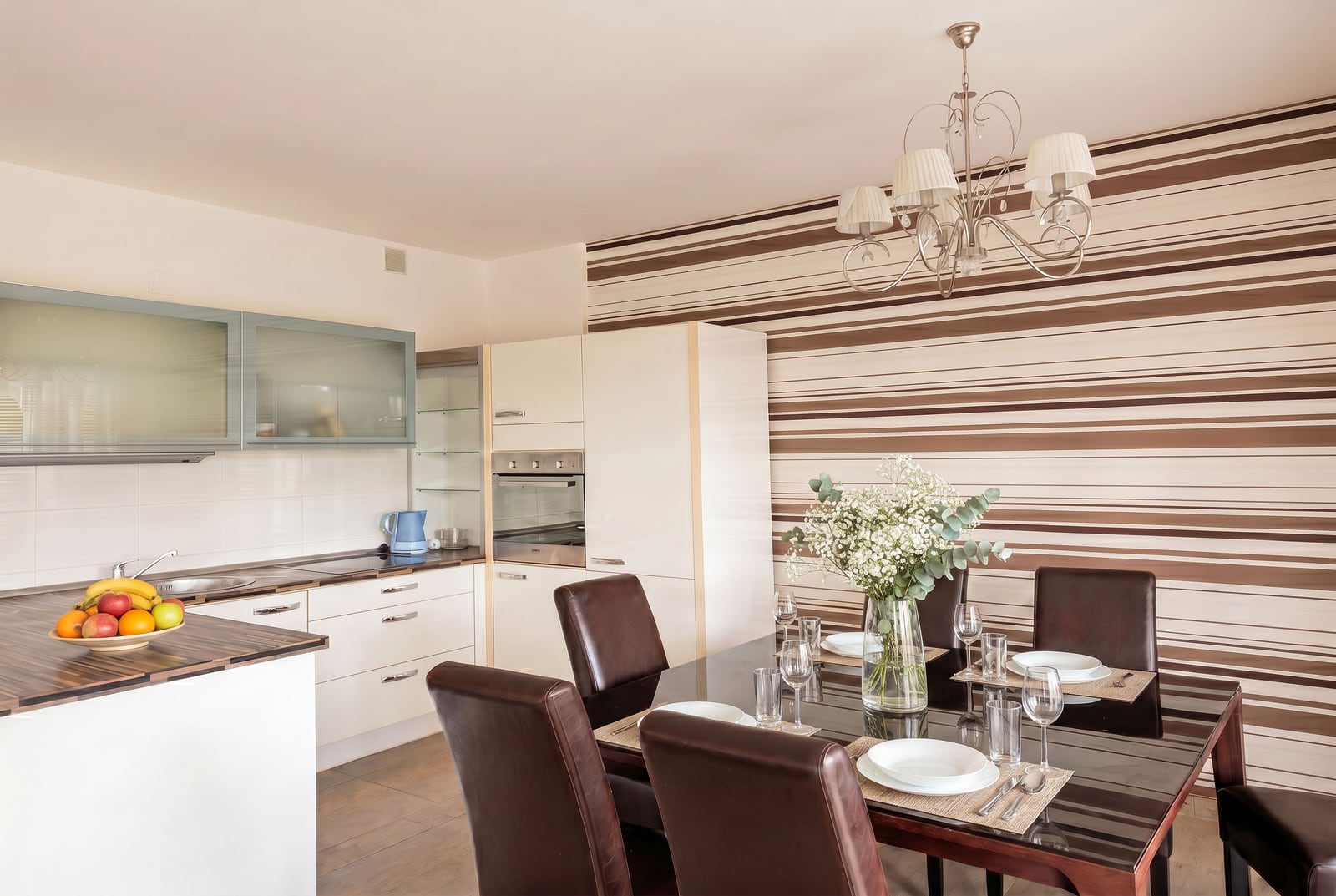 Modern kitchen-dining room in an apartment in Kumbor, Montenegro: dining table, leather chairs, and built-in appliances.