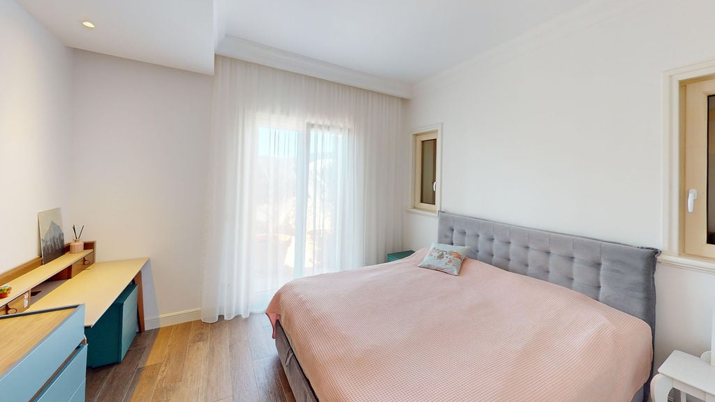 Bright bedroom with a double bed and a desk in an apartment, Luštica, Montenegro. Modern interior.